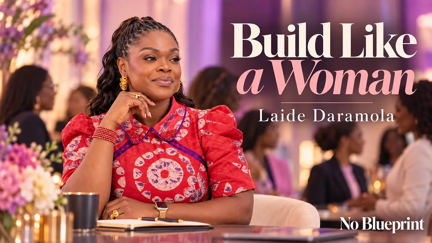 Laide Daramola in a red printed puff-sleeve dress seated at a table with a notebook and coffee cup at an event with attendees and flowers in the background, beside the text 'Build Like a Woman — Laide Daramola,' the hero graphic for the blog post on feminine leadership.